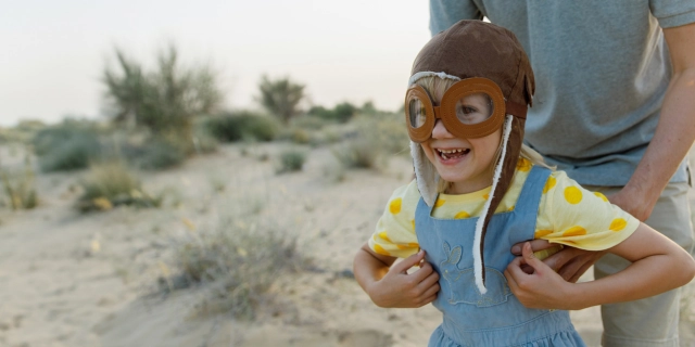 girl dressed as pilot on the sand