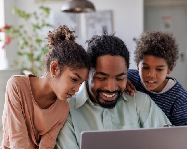 dad and kids looking at computer